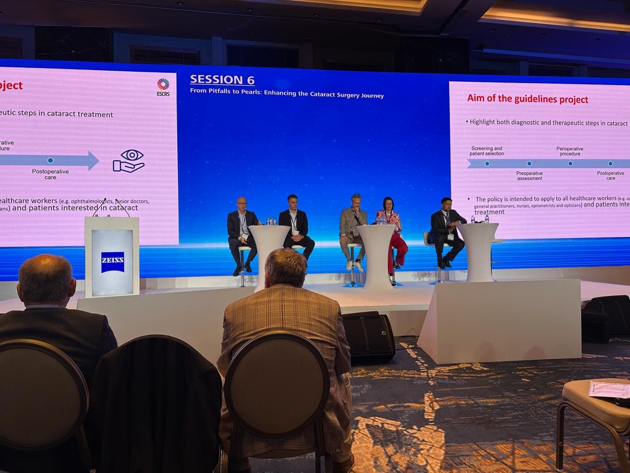 Panel discussion on stage beneath a banner reading Session 6, From Pitfalls to Pearls, Enhancing the Cataract Surgery Journey
