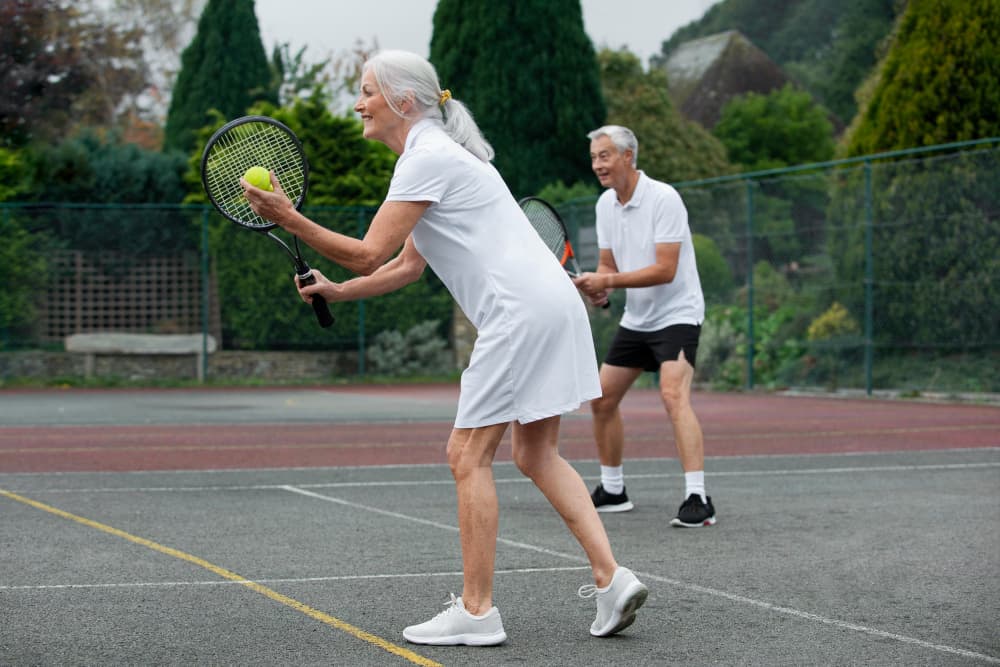 A couple playing tennis together on an outdoor court